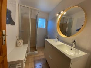 un bagno con lavandino e specchio di Les Amourettes - 2 min à pied Plage - Jardin a La Faute-sur-Mer Altre 32 foto