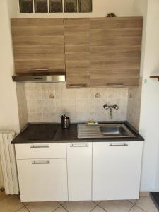 a kitchen with white cabinets and a sink at Residence Hotel Vittoria in Tirrenia