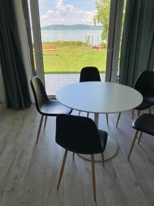バラトンボグラールにあるAttila Beach Boglárの窓付きの客室で、白いテーブルと椅子が備わります。