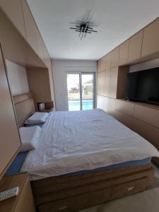 een slaapkamer met een groot bed en een flatscreen-tv bij Villa with Pool & Garden apartment 2 Vuk in Tivat