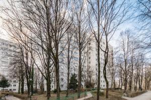 a group of trees in front of a building at Broniewskiego 24A by Homeprime in Warsaw