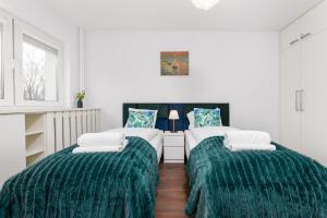 two twin beds in a room with green blankets at Broniewskiego 24A by Homeprime in Warsaw