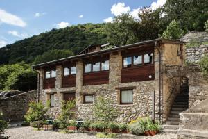 ein Steingebäude mit einem Berg im Hintergrund in der Unterkunft Borgo Selvapiana in Morbegno