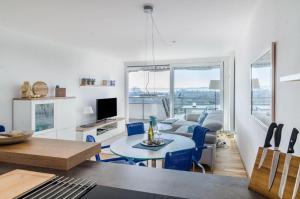 a living room with a couch and a table with chairs at Bodenseepanorama Oberuhldingen in Uhldingen-Mühlhofen