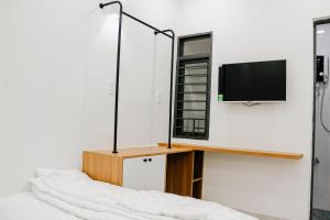 クイニョンにあるFamily Homestay Quy Nhonのベッドルーム1室(壁にテレビ付)、ベッド1台が備わります。