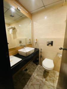 Hotel SS Grandeur في Alambagh: حمام مع حوض ومرحاض ومرآة