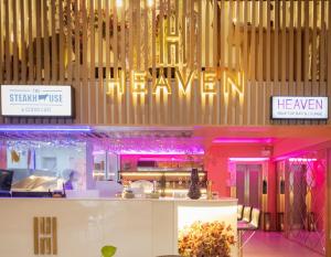 a restaurant with pink lighting and a sign that reads heaven at Heaven Boutique Hotel in Bangkok