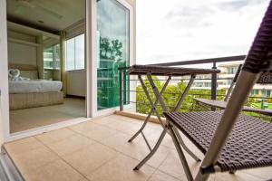 Habitación con balcón, cama y silla. en Hill Side Karon Kata Beach Condo en Phuket