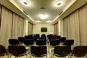 a conference room with black chairs and curtains at Hotel Srbija Garden-FREE PARKING in Belgrade