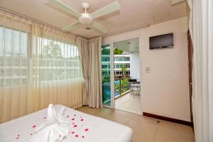 1 dormitorio con 1 cama y ventilador de techo en Hill Side Karon Kata Beach Condo en Phuket