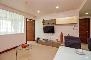sala de estar con TV, mesa y sillas en Hill Side Karon Kata Beach Condo en Phuket