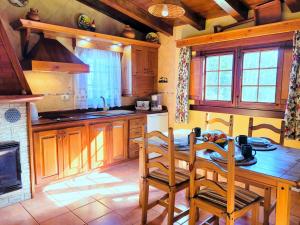 y cocina con mesa, sillas y fogones. en Finca Llano de la cebolla, en Icod de los Vinos