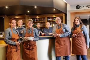 a group of people in aprons standing in front of a counter at Hotel Les 2 Lacs in Clairvaux-les-Lacs