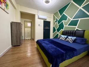 a bedroom with a blue bed and a geometric wall at Family apartment in Tawau city centre in Tawau
