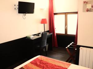 a hotel room with a desk and a bed and a window at Hôtel Restaurant LE SAINT AUGUSTIN in Saint-Amour