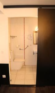 La salle de bains est pourvue d'une baignoire, de toilettes et d'une douche. dans l'établissement Hôtel Restaurant LE SAINT AUGUSTIN, à Saint-Amour