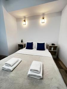 una camera da letto con un grande letto con asciugamani di Cozy Deluxe Apartments in Centre of Historical Suceava a Suceava