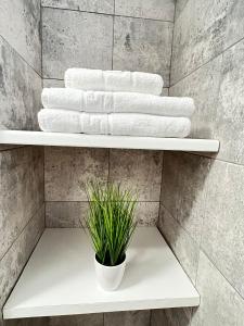 a white towel rack in a bathroom with towels at Cozy Deluxe Apartments in Centre of Historical Suceava in Suceava