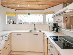 a kitchen with white cabinets and a sink at 8 person holiday home in Hesselager in Hesselager