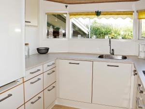 a white kitchen with a sink and a window at 8 person holiday home in Hesselager in Hesselager