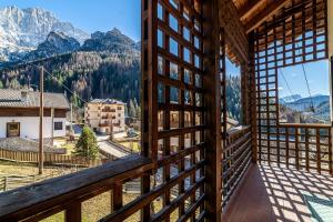 a room with a balcony with a view of mountains at Ai Tabià in Alleghe