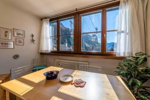 a wooden table in a room with a large window at Ai Tabià in Alleghe