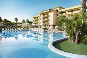 a large swimming pool in front of a hotel at Hotel Village Paradise in Mandatoriccio Marina