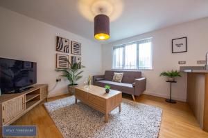 Stay Yorkshire 1st floor Hamilton Mews Apartment في دونكاستير: غرفة معيشة مع أريكة وتلفزيون