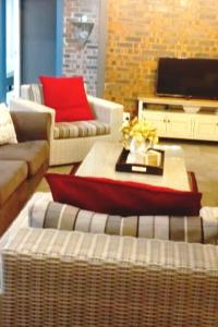 a living room with two couches and a table at Spindrift Seaside Accommodation in Wilderness