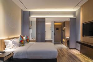 Un pat sau paturi într-o cameră la Ramada Guilin Yangshuo Resort