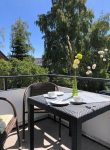 einen Tisch auf einem Balkon mit einer Blumenvase in der Unterkunft Haus Seebad Whg 11 in Grömitz