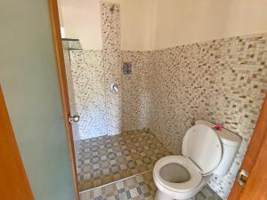 La salle de bains est pourvue d'une douche et de toilettes. dans l'établissement Ganesh Room, à Ubud