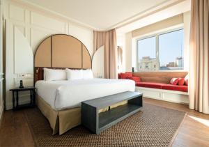 a bedroom with a large bed and a red couch at Only YOU Hotel Valencia in Valencia