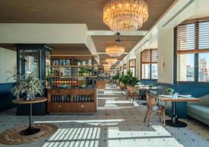 a library with tables and chairs and chandeliers at Only YOU Hotel Valencia in Valencia