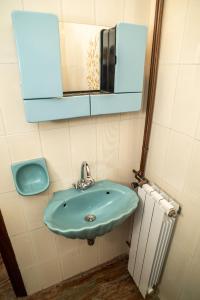 bagno con lavandino blu e specchio di Villa Kontos a Kamena Vourla
