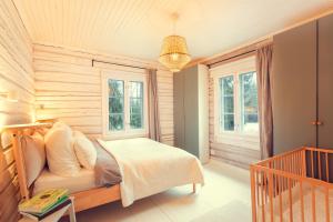 ein Schlafzimmer mit einem Bett und zwei Fenstern in der Unterkunft Beautifully renovated lakeside red cottage in Salo