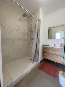 y baño con ducha, bañera y lavamanos. en Appartement T2 piscine et plage en Carry-le-Rouet