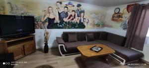Il comprend un salon doté d'un canapé et d'une télévision à écran plat. dans l'établissement Casa Eliadi, à Homorîciu