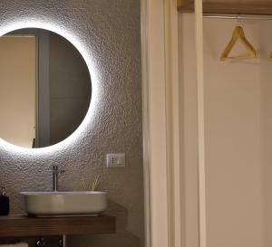 ein Badezimmer mit Waschbecken und Spiegel an der Wand in der Unterkunft Almarì in Cagliari