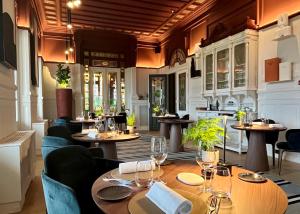 - un restaurant avec des tables et des chaises dans une salle dans l'établissement Château Hôtel Grand Barrail, à Saint-Émilion