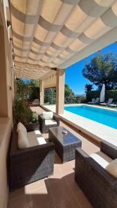 a patio with wicker furniture and a swimming pool at Casa NeGo in Calpe