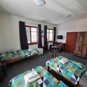 Cette chambre comprend deux lits et un bureau. dans l'établissement Penzion a Restaurace Simanda, à Prague