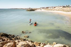 two people on surfboards in the water at a beach at Bavaro Beach Dakhla in Dakhla