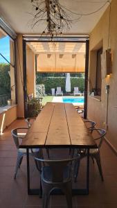 a wooden table and chairs in a room with a pool at Casa NeGo in Calpe