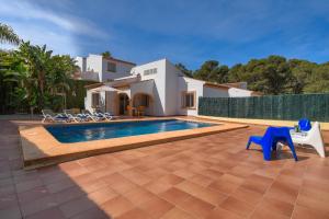 a villa with a swimming pool in front of a house at Monte Rojo in Jávea