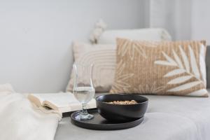 een kom popcorn en een glas wijn op een bank bij Apartament Baltic Sun in Sztutowo