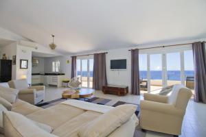 a living room with white furniture and a view of the ocean at Casa Carol on the rocks MHM in Capdepera