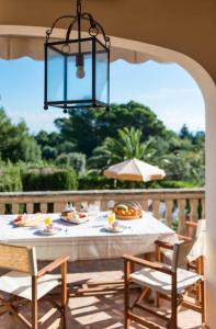 a table and chairs on a patio with a chandelier at Finca Ceguer MHM in Font de Sa Cala