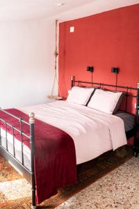 a bedroom with a large bed with a red wall at Casa Mas Montañas in Godelleta