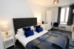 a bedroom with a large bed with blue pillows at Bexley Village Hotel in Bexley